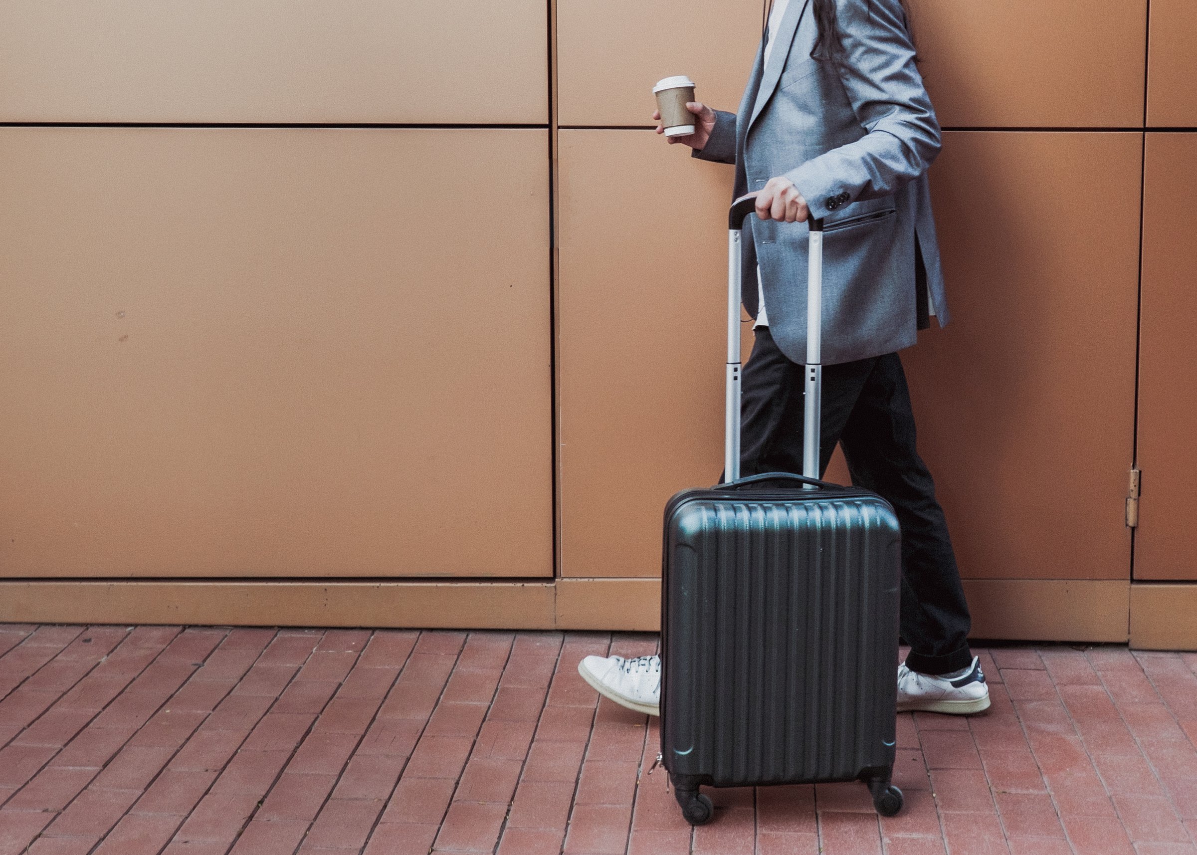 Man with Coffee and Luggage Outdoors